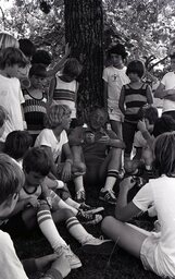 Boys at Campbell University Basketball Camp in 1980 huddle around revered basketball coach John Wooden.