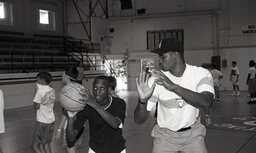 An unidentified coach and camper practice shot technique at Campbell's basketball camp in 1992.