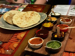 Choice of Five Breads and with all Nine Accompaniments - Traditional Naan, Garlic-Ginger Naan, Spiced Naan, Onion Kulcha, or Paneer Paratha. Accompaniments - Cucumber Raita, Roasted Red Pepper Hummus, Mango Chutney, Tomato-Date Jam, Tamarind Chutney, Coriander Chutney, Garlic Pickle, Red Chile Sambal, or Spicy Jalapeño-Lime Pickle