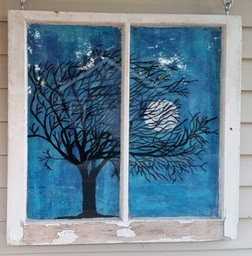 Halloween tree and moon painted on an old window with blue tissue paper background decoupaged. 