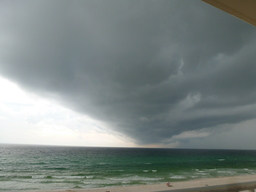 A dark cloud cover is moving in over the open water