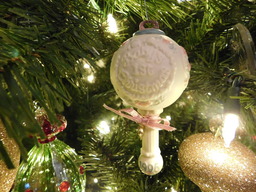 Ornament designed as an ceramic baby rattle. The first Christmas ornament of a young girl