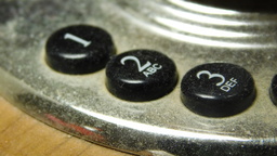 Buttons on the number pad of an old-fashioned candlestick telephone.