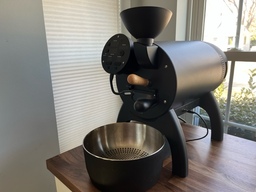 This is a home roaster. It can roast up to one kilogram of green coffee at a time. Beans are poured into the top, roasted as the drum on the inside spins, and are dispensed out of the door in the front.