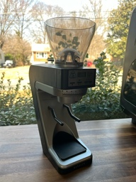 This grinder is used to grind beans for espresso shots, so the grind is very fine. The hopper on top can hold beans and the grinder can be programmed to dispense a certain amount of beans at a time.