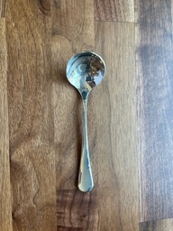 A cupping spoon is used for tasting coffee samples. The shape helps dispel heat so it cools faster, and it provides a wider surface area for testing aroma and flavor.