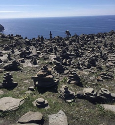 A number of cairns, man-made stack of stones, on the Cliffs of Moher. Often a tourist tradition to create a cairn or add on to an existing one. 