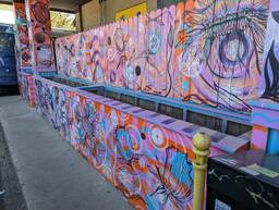 The Charleston Pour House is a live music venue located at 1977 Maybank Highway in James Island, SC. This mural is of flowers and a human eye, painted with a swirling background of blue, orange, pink, and purple.