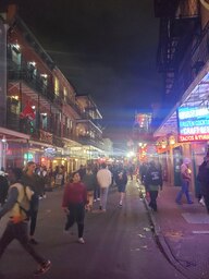 Bourbon Street at night during the final week of Mardi Gras 2022.  This shopping area is well known for costumes, souvenir shops, bars, open-carry alcohol laws, and tourists looking for a good time. 