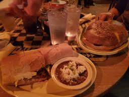 A typical lunch served at The Napoleon House, a restaurant operating within one of the French Quarter's oldest buildings.  Left to right: a dressed po' boy, red beans and rice, and a muffaletta.