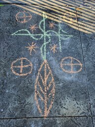 A veve drawn in chalk on the pavement near Congo Square, a section of the Louis Armstrong Park.  A veve is a religious symbol of the Vodou (Voodoo) faith, meant to invite good spirits.  This veve invites Papa Legba, a kindly grandfather figure, to offer his presence and blessing.